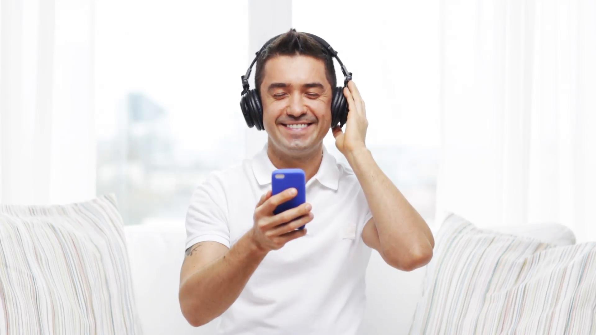 technology-people-lifestyle-and-distance-learning-concept-happy-man-with-smartphone-and-headphones-listening-to-music-at-home_eu29zj2he__F0000.jpg